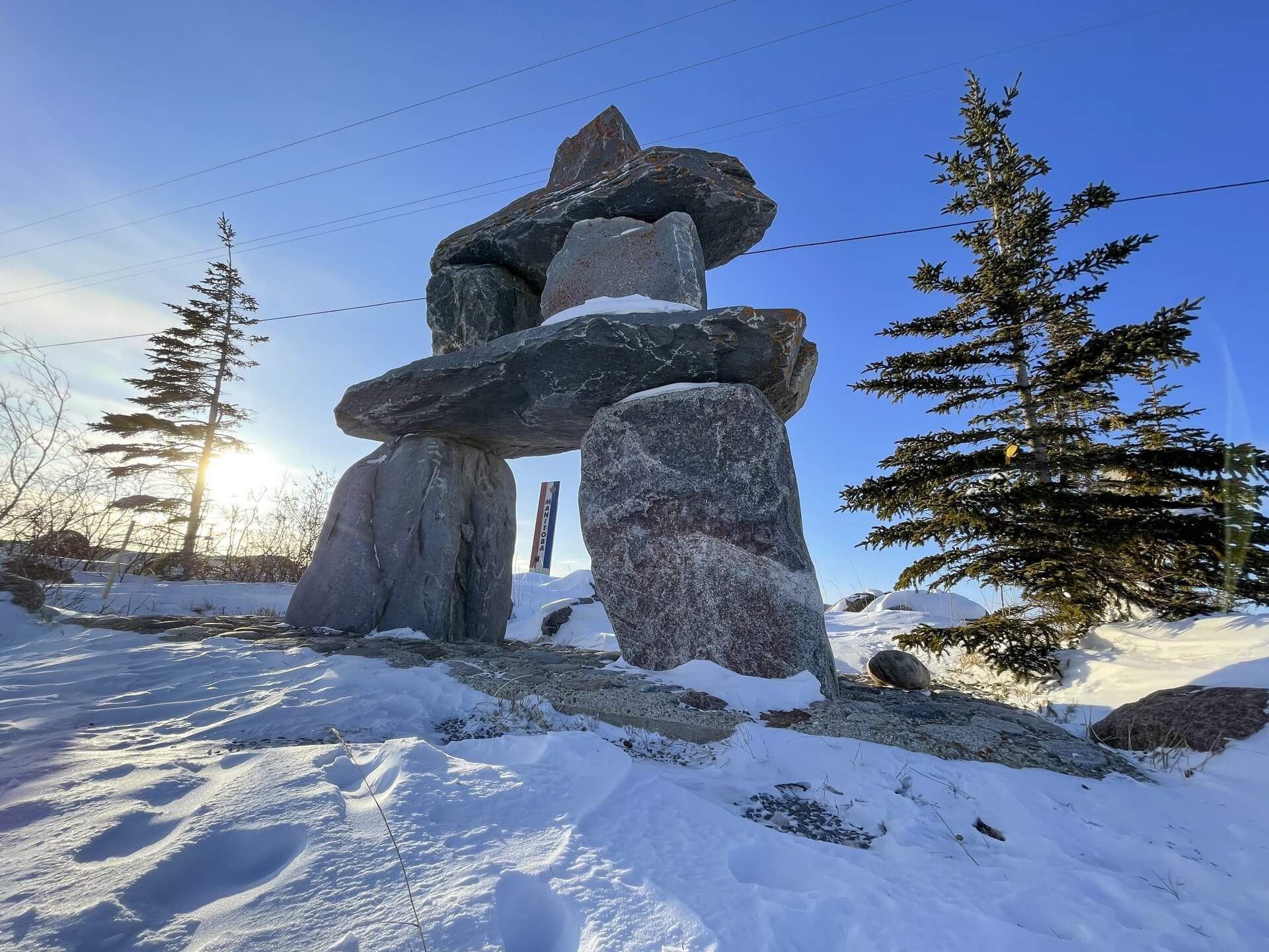An inuksuk made from rocks on a snowy landscape in Churchill 